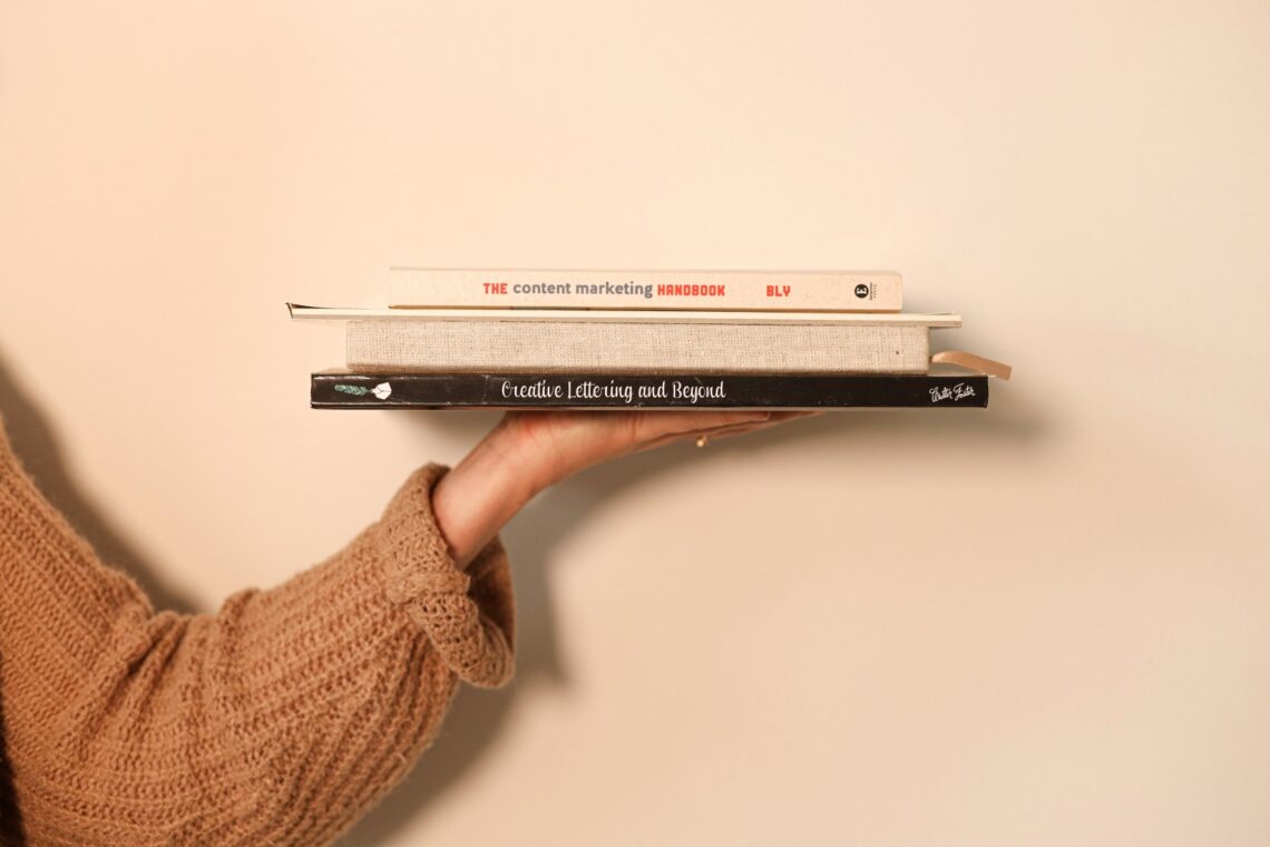 hand met boeken voor kalligrafie en content marketing